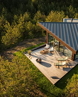 Modern outdoor living space with the contemporary Mix 850 fire pit creating warmth and atmosphere on a patio beside a glass-walled home